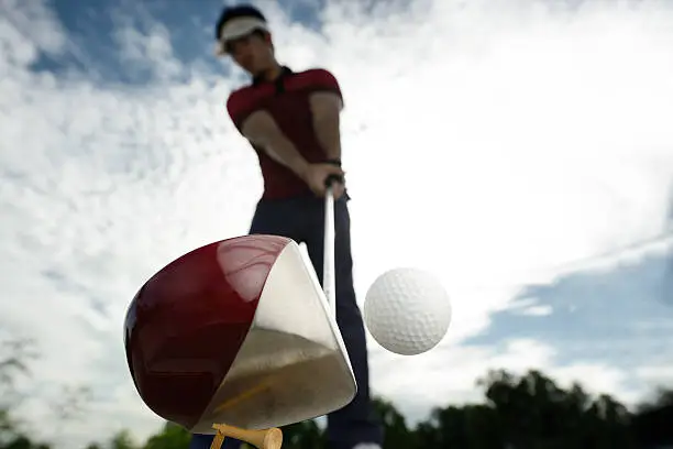 Photo of Upward view of a golfer mid golf swing