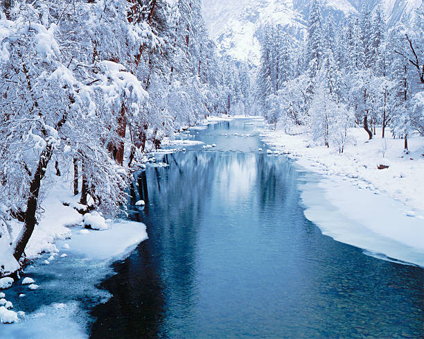 Winter in Yosemite National Park The Merced River flows through Yosemite National Park, CA snow river stock pictures, royalty-free photos & images