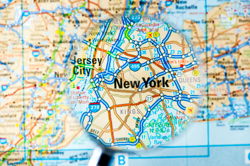 Cities under magnifying glass on map: New York