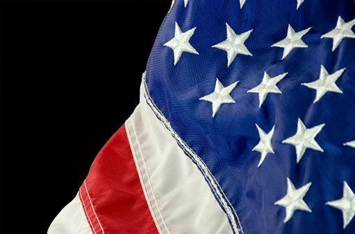 An American flag close-up and on a black background with copy space.