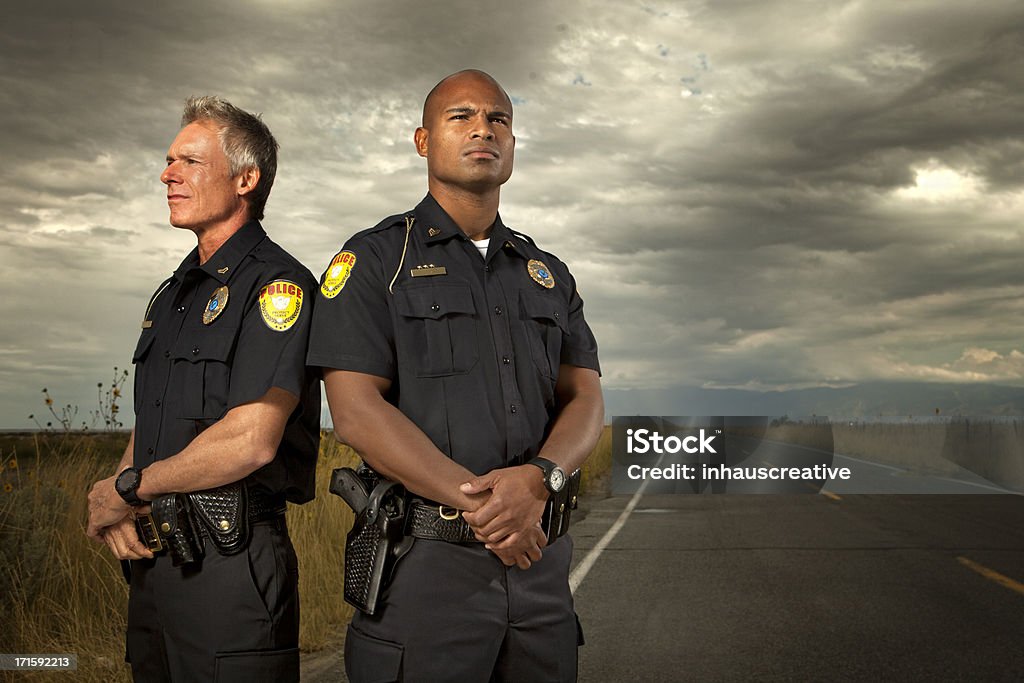 Due Poliziotti in piedi su una strada tranquilla - Foto stock royalty-free di Guardia di sicurezza