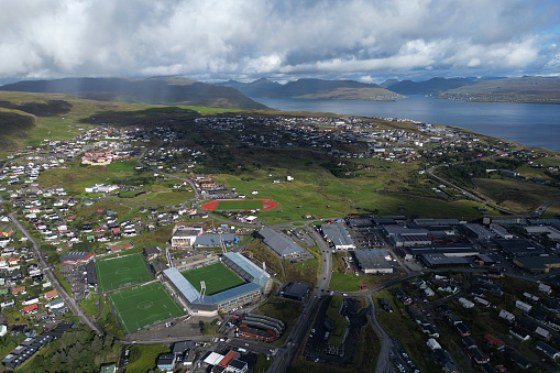 Aerial view of Torshavn on a sunny day with the largest stadium of Faroe Islands in the foreground.