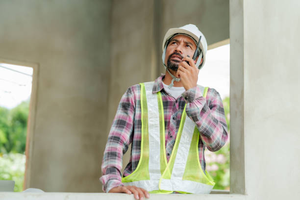 istock In a home construction area, engineers are using walkie-talkies. Operate a crane at height and wore a gleaming outfit Wear a safety hat In a house under construction to control work 1715966899