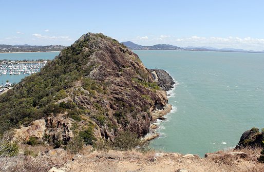 View of a mountain, the ocean, trees and boats from the Rosslyn Bay Lookout at Yeppoon in Queensland, Australia