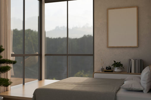 A modern and comfortable bedroom interior design with a comfy bed, a bedside drawer, a blank frame mockup on a wall, and large window with a beautiful mountain view. 3d render, 3d illustration