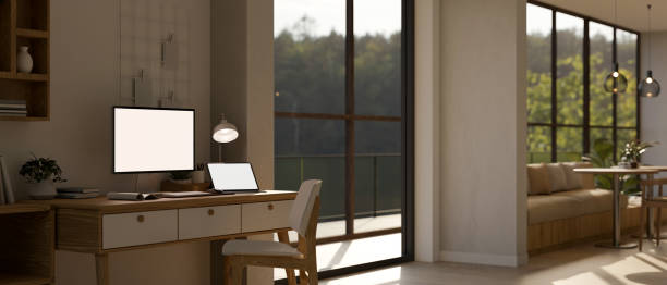 istock A white-screen computer and laptop mockup on a desk in a modern spacious office. 1716017673