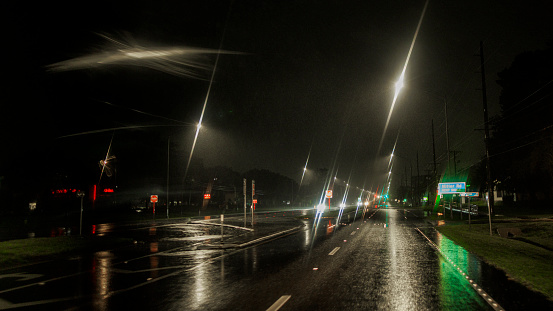 Navigating wet roads of small town. Illuminated streets and defocused light trails among the road in Tampa, Florida