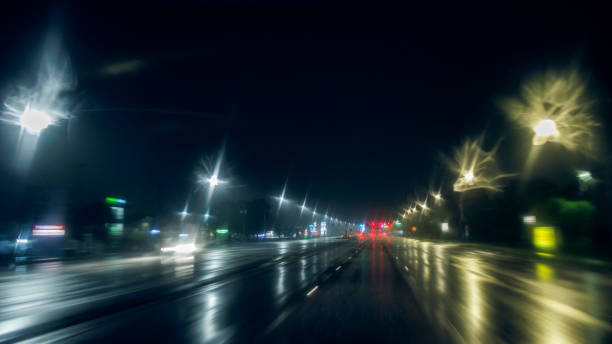 istock Night drive on wet illuminated road: Moving through heavy rain after a storm. Blurred lights and defocused trails 1716024150