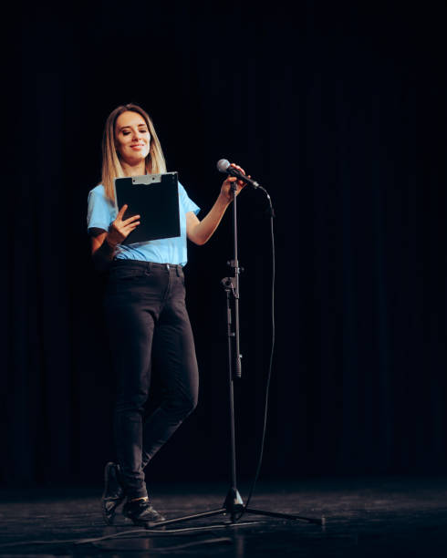 Public Speaker Holding a Clipboard Taking on a Microphone ion a Stage