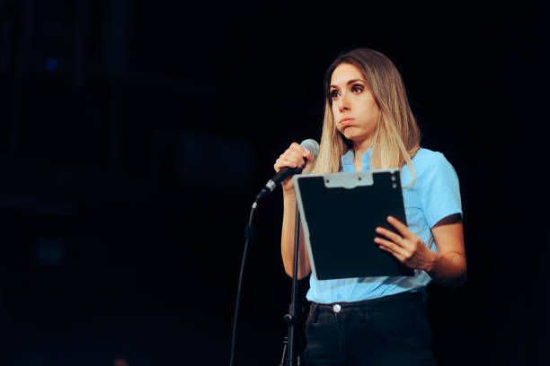 istock Stressed Speaker Holding a Clipboard Taking on a Microphone ion a Stage 1716054762