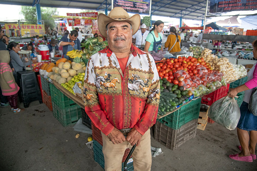 A Mexican, proud of his shirt and hat, happily poses at a market in San Miguel de Allende, Mexico.