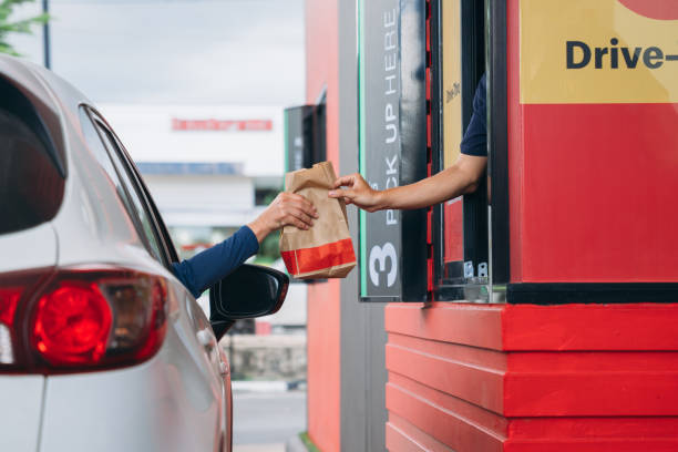 Young Man receiving coffee at drive thru counter., Drive thru and take away for protect covid19. Young Man receiving coffee at drive thru counter., Drive thru and take away for protect covid19. chief of staff stock pictures, royalty-free photos & images
