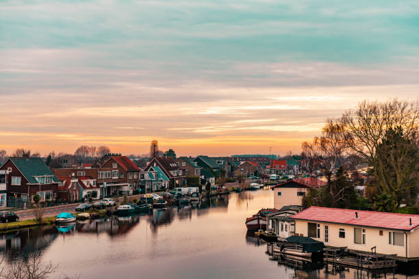 This is a view of the Sloten neighborhood view with residential homes lining the canal in Amsterdam at sunset.