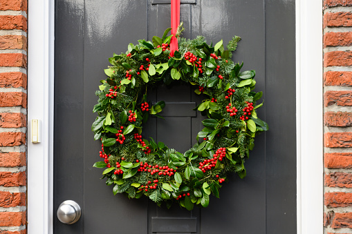 This is a photograph of a Christmas wreath decorating a front door in the Netherlands.