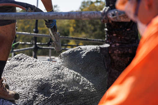 Construction Worker Spraying Concrete On Construction Site