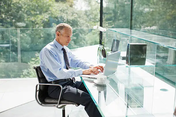 Photo of Businessman using laptop in office