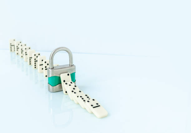 istock Padlock stopping domino effect on white background. 1716294646