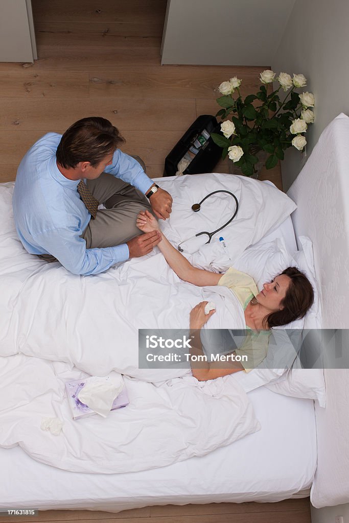 Medico controllando il paziente dell'impulso in casa chiamata - Foto stock royalty-free di Letto