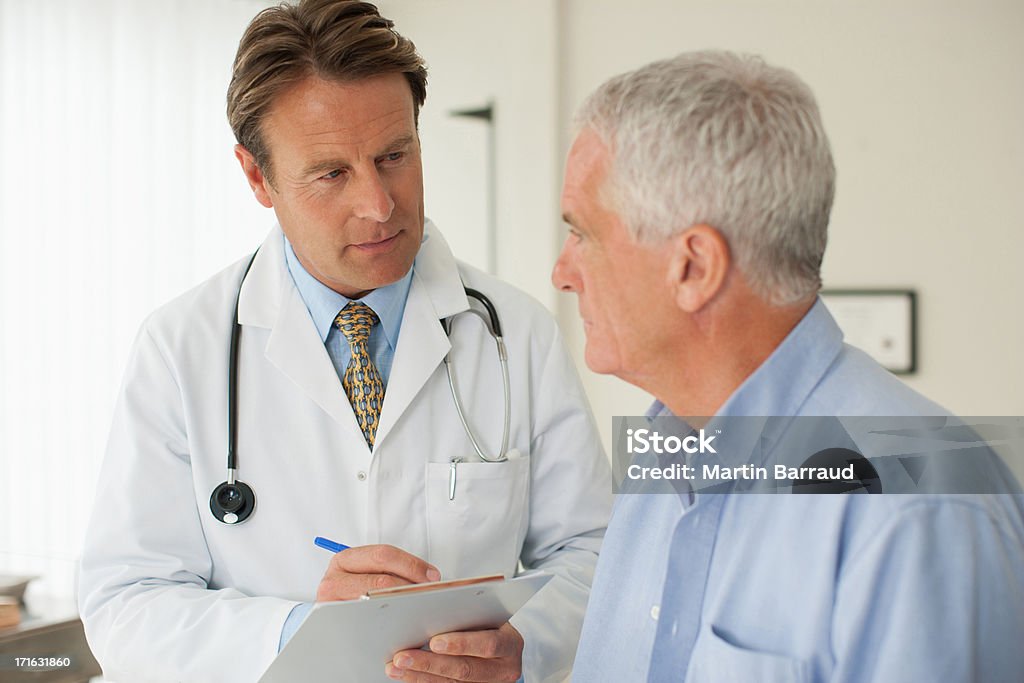 Doctor hablando con el paciente en el consultorio médico  - Foto de stock de Doctor libre de derechos