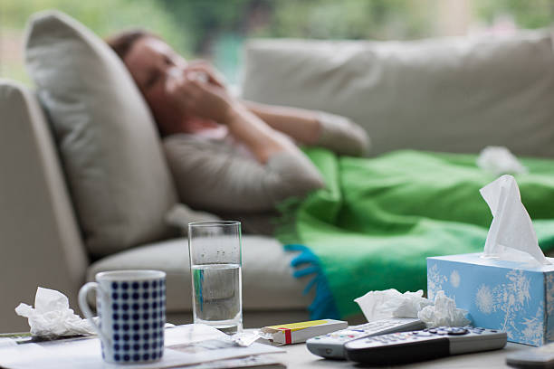 femme malade allongé sur un canapé se moucher - mouchoir en papier photos et images de collection