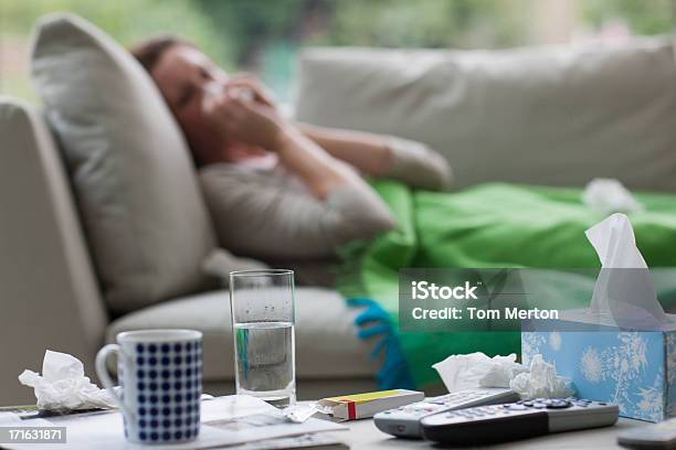 Sick Woman Laying On Sofa Blowing Nose Stock Photo - Download Image Now - Cold And Flu, Illness, People