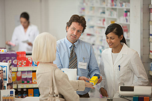 farmacéuticos de responder a las preguntas para el cliente en farmacia - pharmacist mature adult smiling senior adult fotografías e imágenes de stock