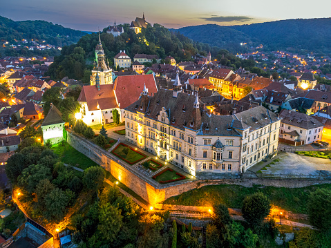 Aerial of the medieval fortress and town of Sighisoara at dusk. Photo taken on 14th of August 2023 in Sighisoara, Transylvania region, Romania.