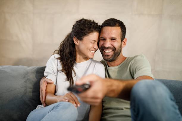 istock Happy couple enjoying while watching TV at home. 1716347386