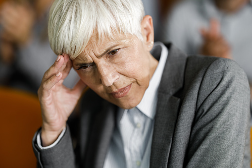 Worried mature businesswoman thinking of her problems in the office.