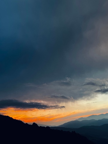 A scenic view of mountains at a cloudy sunset