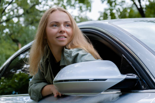 femme blonde sortant la tête du pare-brise de la voiture. les jeunes touristes explorent les voyages locaux en créant de vrais moments francs. expressions de vraies émotions de s’évader et de se rafraîchir à l’air pur - sévader du réel photos et images de collection