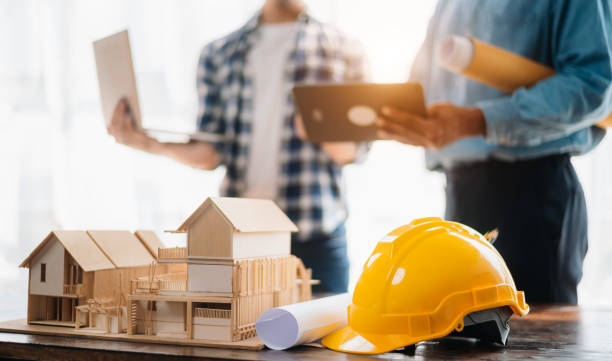 istock Engineer desk with object paper and tablet with blurry engineer teamwork hardworking to consults about their building project. 1716380544