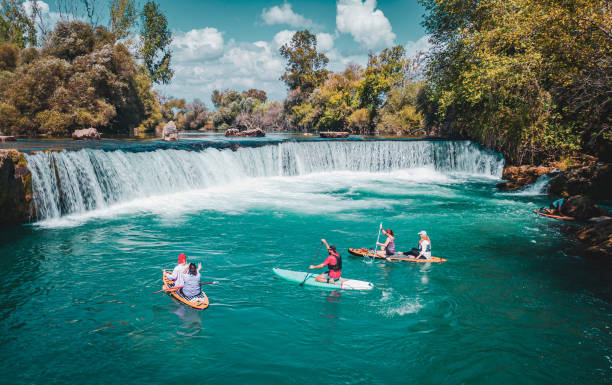 istock A group of white people floating on a supboard around the waterfall in the river 1716385493