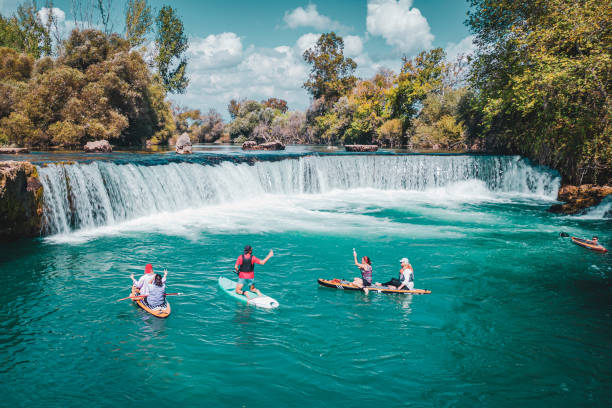 istock A group of white people floating on a supboard around the waterfall in the river 1716386579