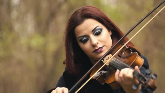 Young Woman Playing Violin In Forest