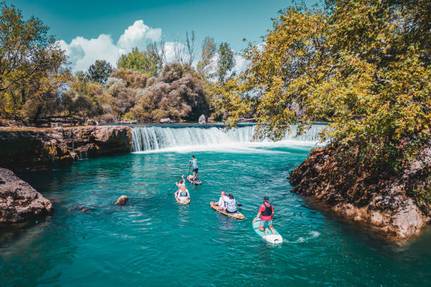 istock A group of white people floating on a supboard around the waterfall in the river 1716394267