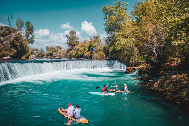istock A group of white people floating on a supboard around the waterfall in the river 1716395385