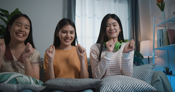 Group of young women in the comfort of their home as they practice dancing through smartphone. Experience the joy, creativity, and togetherness of their dynamic dance routine