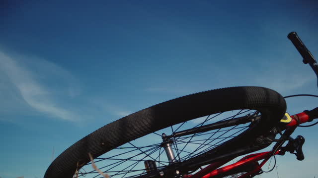 Part of a bicycle, steering wheel and wheel on a background of blue sky
