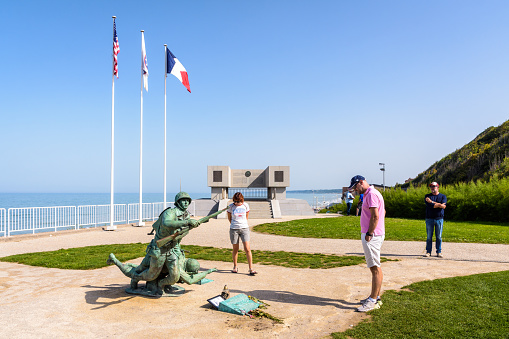 Vierville-sur-Mer, France - Sept. 5, 2023: Tourists stand in front of the Ever Forward statue erected in 2014 in memory of the US 29th Division's soldiers who landed on Omaha Beach on D-Day, 6 June 1944.