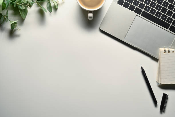istock White office desk with laptop, cup of coffee, notepad and plant. Top view with space for text 1716435631