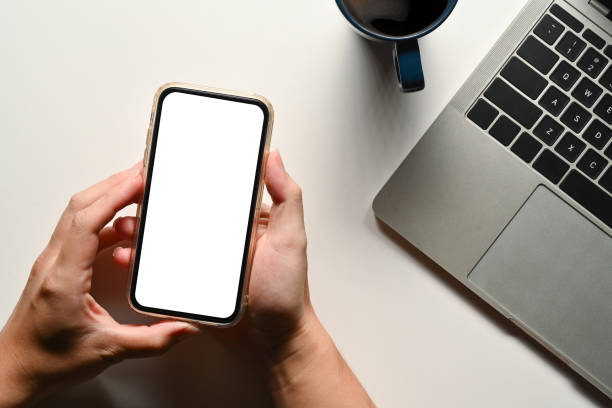 istock Above view of man using mobile phone over white office desk. Blank screen for your advertising text message 1716436092