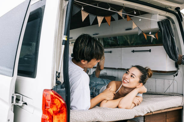 istock Happy Japanese couple having a conversation while laying in their van 1716460643