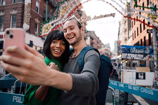 Young multiethnic and transgender couple exploring New York City during their honeymoon.