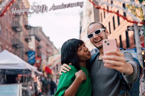 Young multiethnic and transgender couple exploring New York City during their honeymoon.