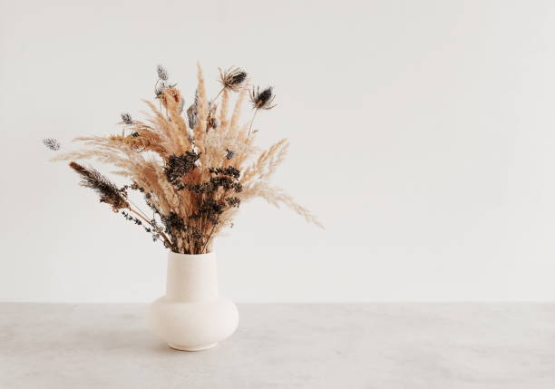 istock Dry flowers bouquet in ceramic vase near white wall.  Copy space 1716510492
