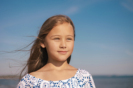Close up Portrait of Happy Cute Girl in  During Summer Vacation On Exotic Tropical Beach. Wind in a hair. Family Journey