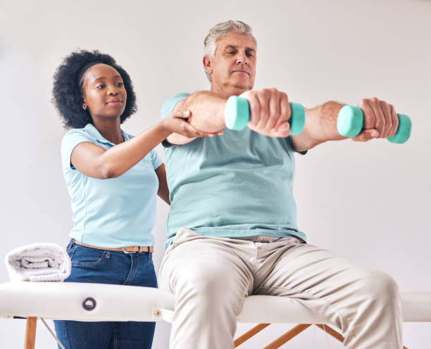 istock Old man, exercise and physiotherapy with dumbbell for wellness and muscle training on bed with black woman. Healthcare, physiotherapist and senior with workout for healing help, support and fitness 1716536517