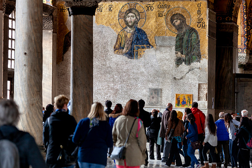 Istanbul,Turkey-Mar 08,2013:Mosaic of Jesus Christ in the old church of Hagia Sophia in Istanbul, Turkey and the follower tourists.Museum of Hagia Sofia is one of the greatest examples of Byzantine architecture and mostly visited landmark by tourists in Istanbul.