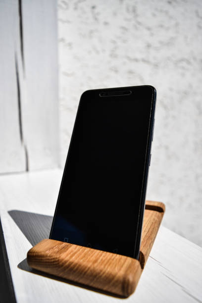 istock Black mobile phone stands on a wooden stand 1716545465
